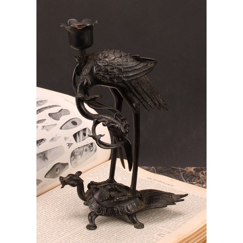 277 - A Chinese dark patinated bronze candlestick, cast as a crane standing upon a turtle, 24cm high, six ... 