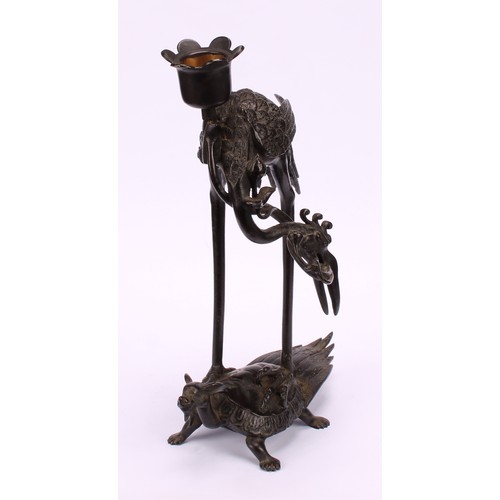 277 - A Chinese dark patinated bronze candlestick, cast as a crane standing upon a turtle, 24cm high, six ... 