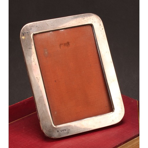 665 - A George V silver rounded rectangular easel photograph frame, quite plain, 18cm high, Chester, 1911