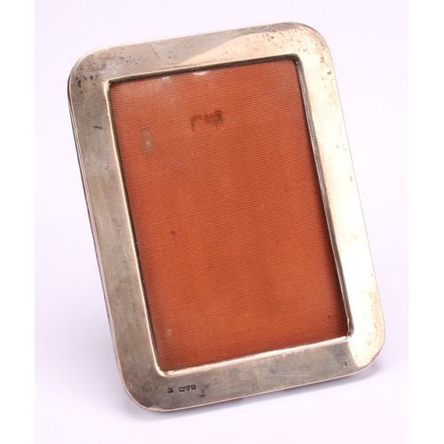 665 - A George V silver rounded rectangular easel photograph frame, quite plain, 18cm high, Chester, 1911