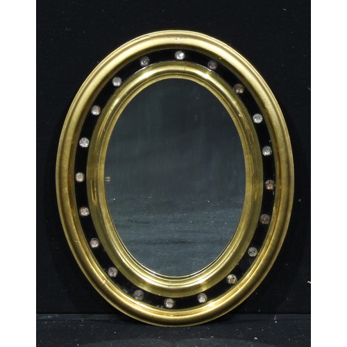 1898 - An Irish gilt and ebonised oval looking glass, plain mirror plate, the border set with twenty crysta... 