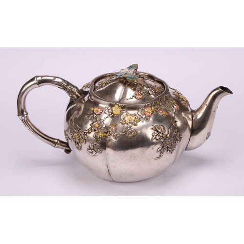 679 - A Japanese silver and enamel melon shaped teapot, decorated in polychrome with blossoming prunus, bu... 