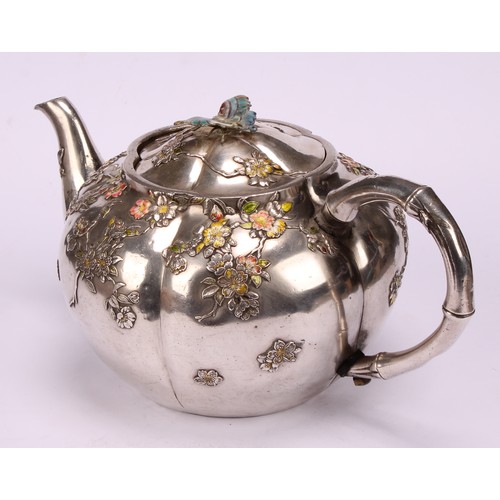 679 - A Japanese silver and enamel melon shaped teapot, decorated in polychrome with blossoming prunus, bu... 