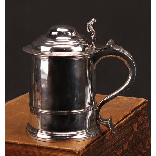 622 - A George I silver cylindrical tankard, hinged domed cover with scroll thumbpiece, three-quarter gird... 