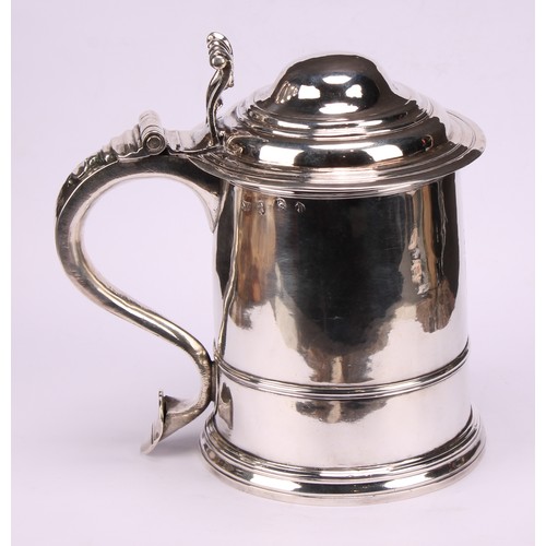 622 - A George I silver cylindrical tankard, hinged domed cover with scroll thumbpiece, three-quarter gird... 