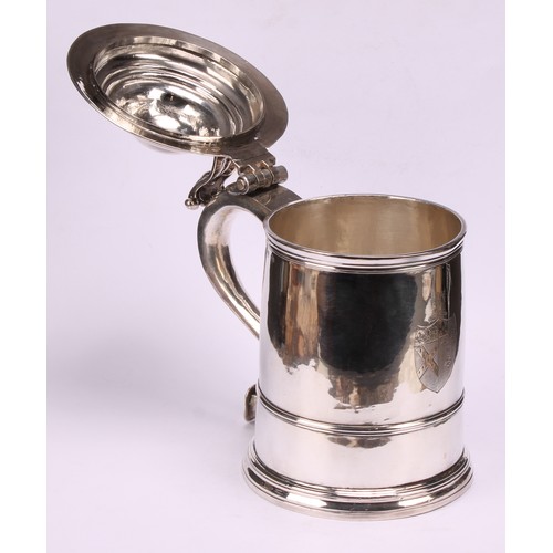 622 - A George I silver cylindrical tankard, hinged domed cover with scroll thumbpiece, three-quarter gird... 