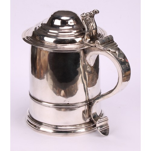 622 - A George I silver cylindrical tankard, hinged domed cover with scroll thumbpiece, three-quarter gird... 