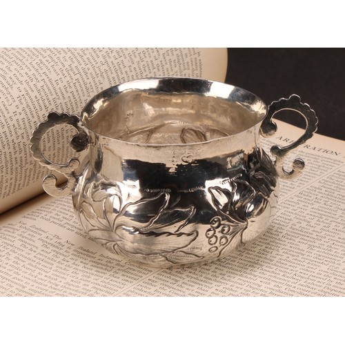 594 - A Charles II Provincial silver porringer, repousse chased with flowers and scrolling leaves, 13.5cm ... 