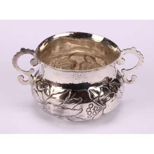 594 - A Charles II Provincial silver porringer, repousse chased with flowers and scrolling leaves, 13.5cm ... 