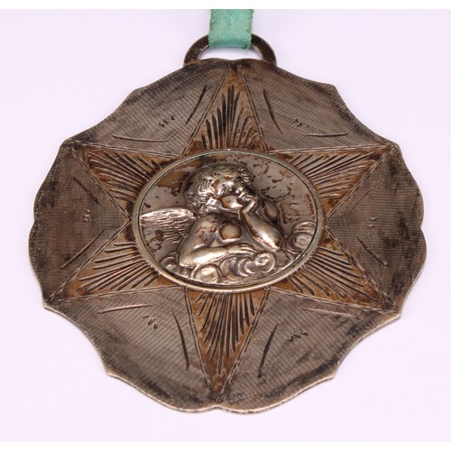 604 - A Continental silver badge or medal, possibly ecclesiastical, chased with a putto, 10.5cm over loop,... 