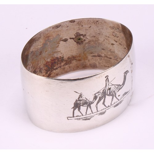 677 - A harlequin suite of four Iraqi silver and niello napkin rings, decorated with genre scenes and land... 