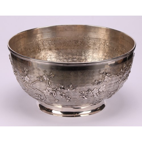 599 - A Chinese export silver punch bowl, chased and applied with blossoming prunus on a meandrous ground,... 