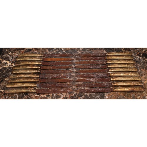 537 - A set of eighteen French silver-gilt fruit knives, the loaded hafts chased in the Neo-Classical tast... 