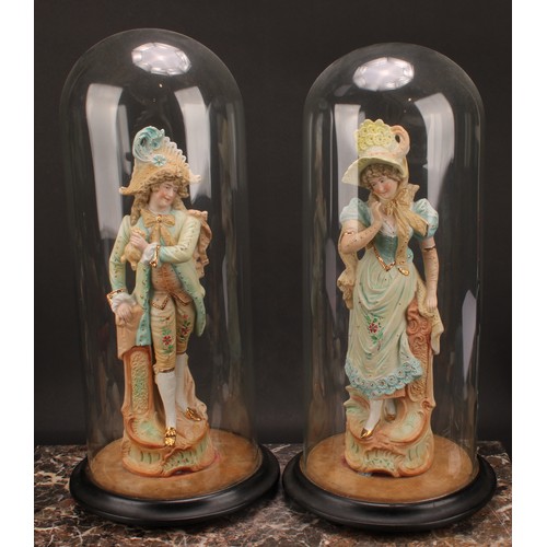 144 - A pair of continental figures, gallant and companion, under a pair of large clear glass domes, with ... 