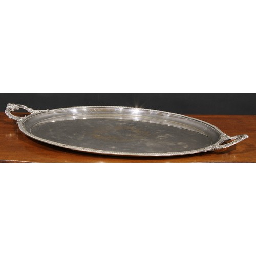 568 - A Victorian EPNS oval two-handled serving tray, gadrooned border, the field bright-cut engraved with... 