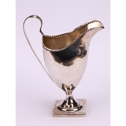 626 - ***COLLECTING 09/09***A George III helmet shaped cream jug, punch beaded rim, reeded scroll handle, ... 