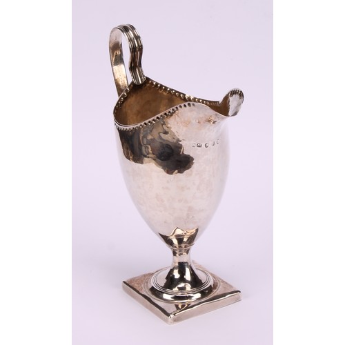 626 - ***COLLECTING 09/09***A George III helmet shaped cream jug, punch beaded rim, reeded scroll handle, ... 