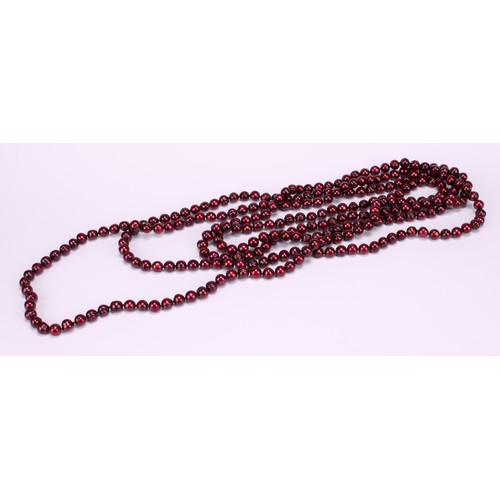 952 - A very long single strand of cherry red Tahitian circle pearls, 125cm drop; a single strand of metal... 