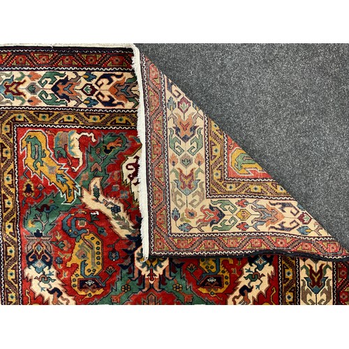 124 - A Persian Caucasan rug, floral field in tones of green, mustard, red, blue and red, approx 234cm x 1... 