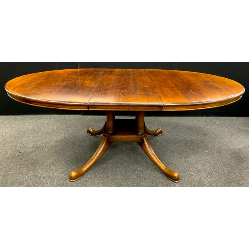 142 - A George III revival oak extending dining table, oval top, pedestal base with four swept cabriole le... 