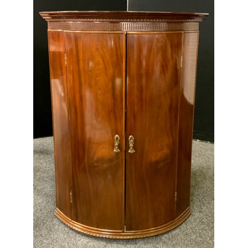 190 - A George III mahogany bow-front corner cupboard, 103cm high x 74cm wide x 53.5cm deep.