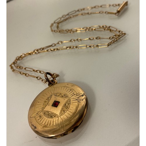 284 - A rolled gold circular locket pendant necklace, containing photographs of WWI soldier and sweetheart... 