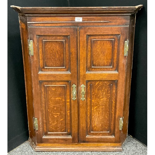 119 - A 19th century oak wall hanging corner cupboard, four panel doors, brass H hinges, 98cm x 76cm x 43c... 