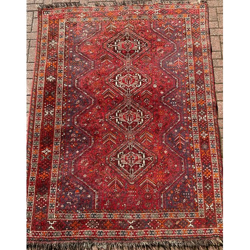 232 - A Persian Hamadan type rug, hand-knotted with a central row of four diamond-shaped medallions, withi... 