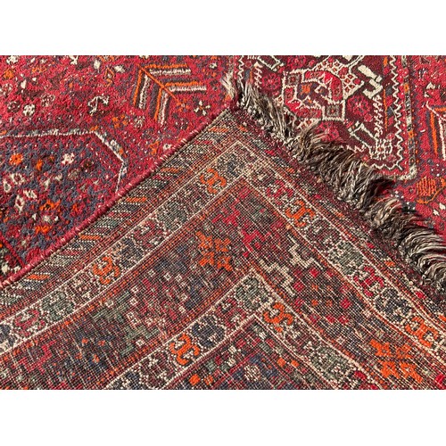 232 - A Persian Hamadan type rug, hand-knotted with a central row of four diamond-shaped medallions, withi... 