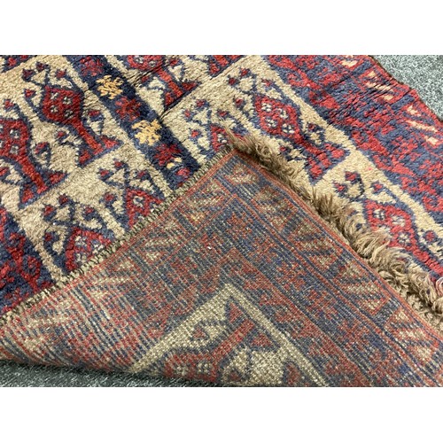 238 - A mid 20th century Afghan type woollen rug, knotted in tones of red, deep blue, and grey, 120cm x 76... 