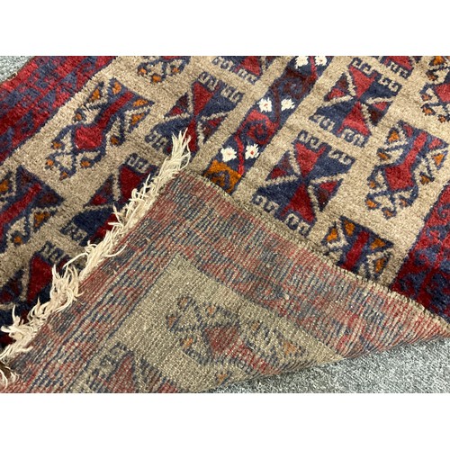 238 - A mid 20th century Afghan type woollen rug, knotted in tones of red, deep blue, and grey, 120cm x 76... 