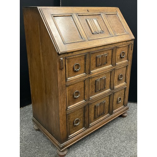 101A - A 'Linen-fold' carved oak bureau, 97cm high x 73.5cm wide x 41cm deep.