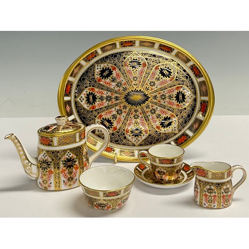 11 - A Royal Crown Derby Imari 1128 pattern miniature tea set on oval tray, comprising teapot, milk jug a... 