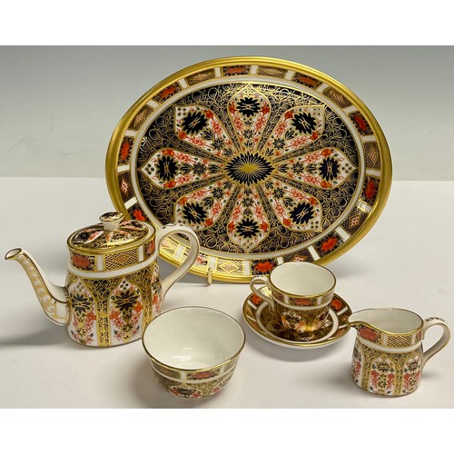 11 - A Royal Crown Derby Imari 1128 pattern miniature tea set on oval tray, comprising teapot, milk jug a... 