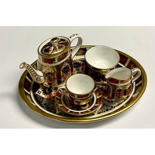 11 - A Royal Crown Derby Imari 1128 pattern miniature tea set on oval tray, comprising teapot, milk jug a... 