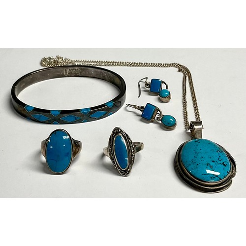 203 - A sterling silver pendant set with a polished turquoise cabochon, 5cm over suspension loop, silver n... 