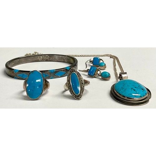 203 - A sterling silver pendant set with a polished turquoise cabochon, 5cm over suspension loop, silver n... 