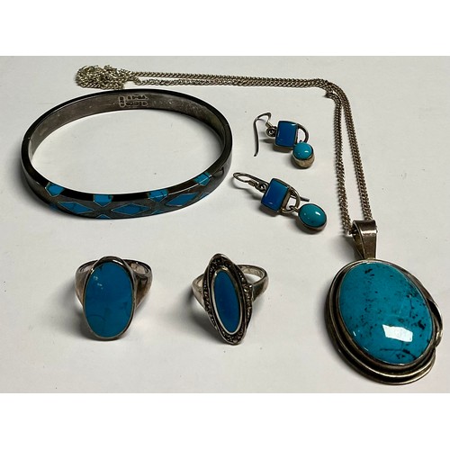 203 - A sterling silver pendant set with a polished turquoise cabochon, 5cm over suspension loop, silver n... 