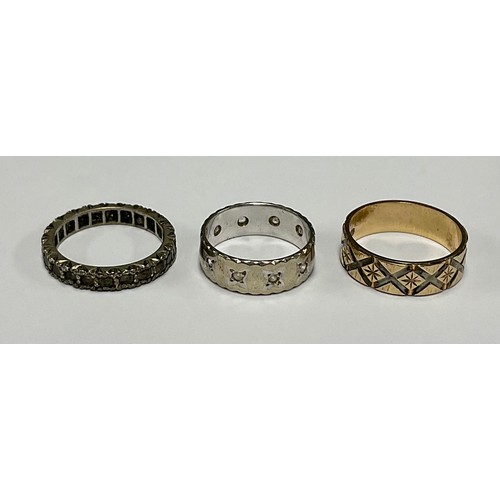 190 - A 9ct gold ring, engraved with bright cut diamond shapes; another, white gold; another, similar (3)