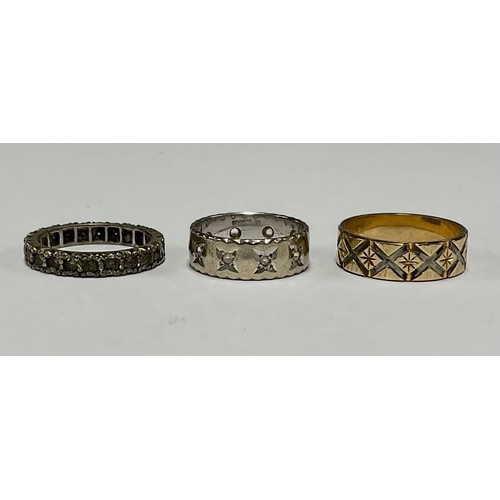 190 - A 9ct gold ring, engraved with bright cut diamond shapes; another, white gold; another, similar (3)