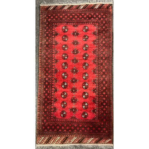 96 - A Middle Eastern Bokhara rug / carpet, hand-knotted in rich red, with black and white, 190cm x 100.5... 