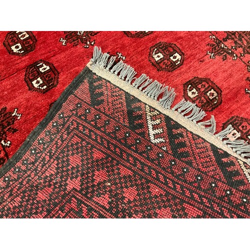 96 - A Middle Eastern Bokhara rug / carpet, hand-knotted in rich red, with black and white, 190cm x 100.5... 