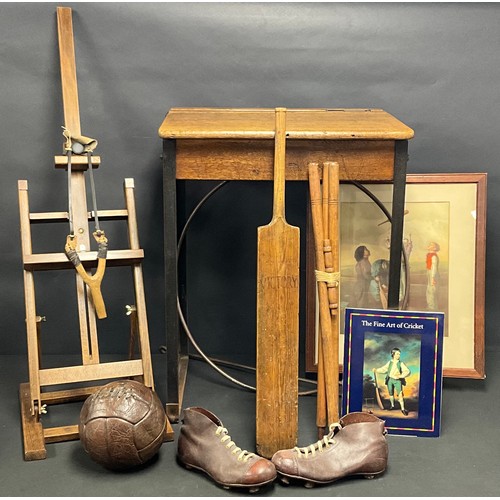 605 - An early 20th century brown leather football, child's football boots, cricket bat and stumps with cr... 