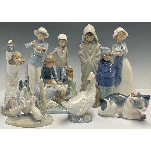 613 - A Spanish porcelain Nao figure, Girl with Puppy, 25cm; Boy With Puppy; kitten; goose; Boy In Duffel ... 