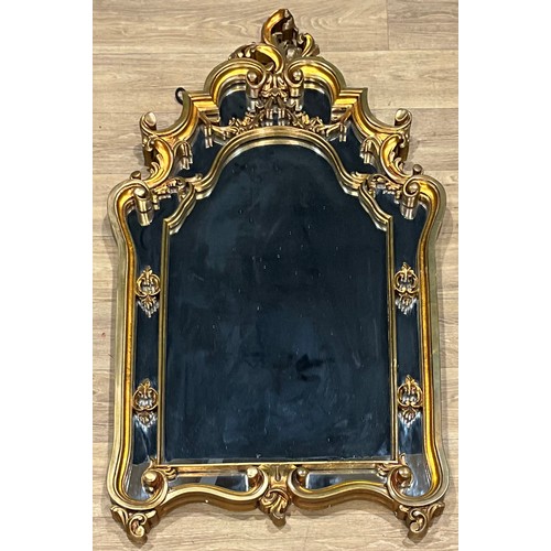 674 - A large rococo style looking glass, shaped mirror plate within gilt moulded frame, 128cm high