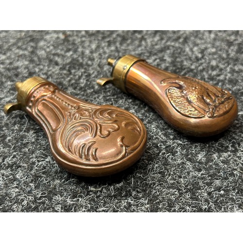 2422 - Pair of Copper Pistol Powder Flasks. One unmarked with a embossed floral design 110mm in length. The... 