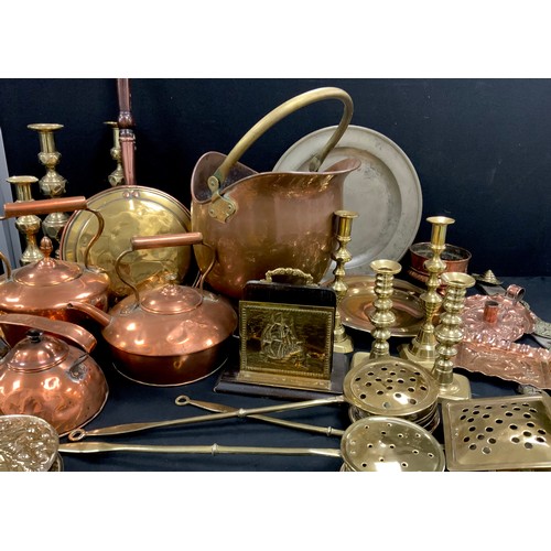 61 - Brass and copper including a copper scuttle, kettles; arts and crafts copper chamberstick and dish, ... 