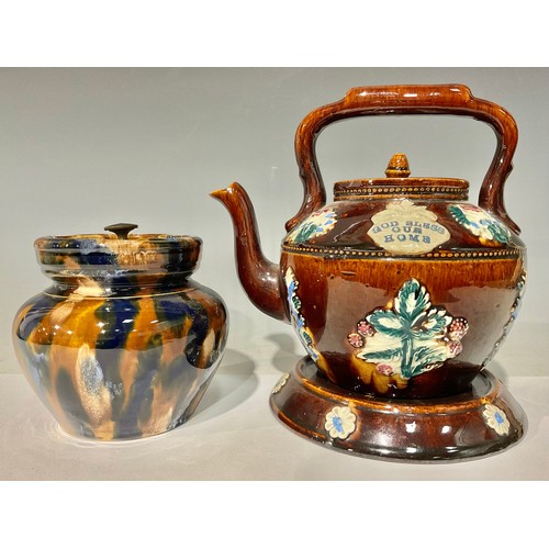 23 - A Derbyshire treacle glazed majolica bargeware teapot and stand, inscribed 'God Bless Our Home', spr... 