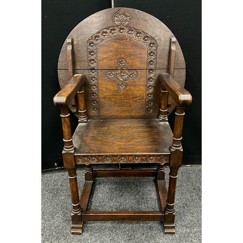 105 - A carved oak monks chair, 102cm high x 69.5cm wide x 49cm deep, c.1930.