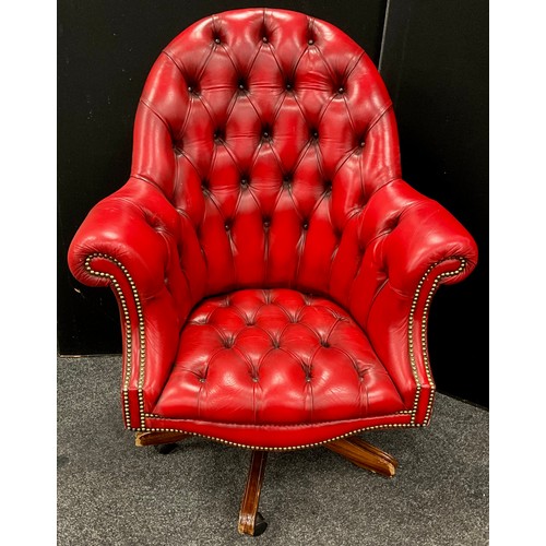 106 - A chesterfield office chair, ox-blood red leather, button-back, rotating, rise-and-fall base.